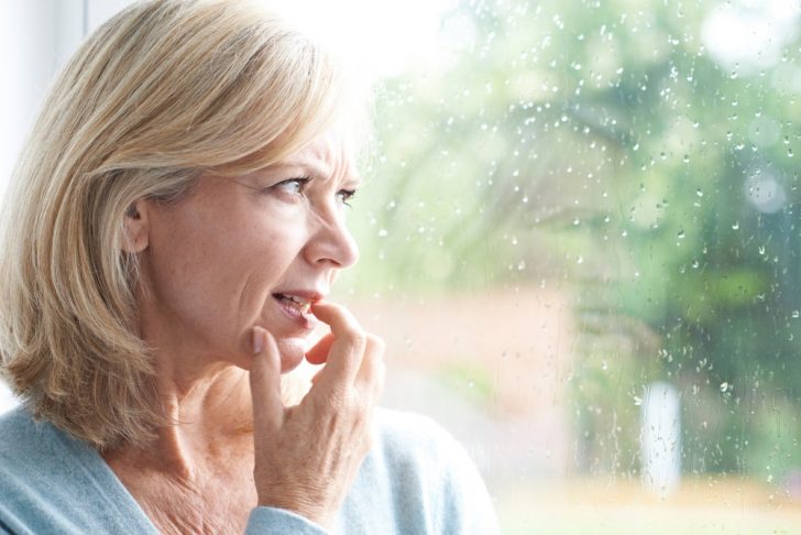 sad middle-aged woman looking out of window